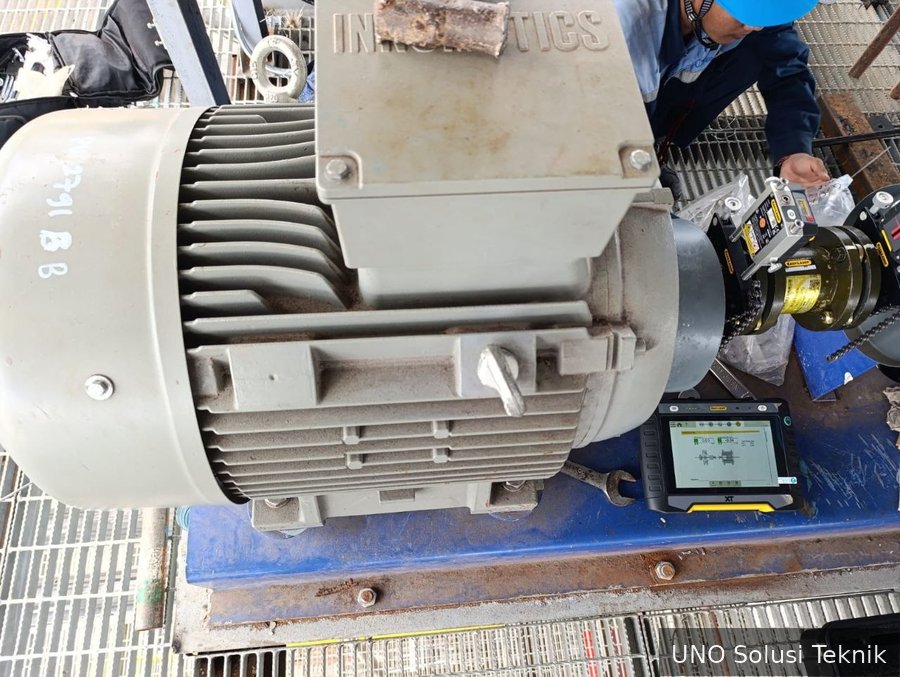 Teknisi UNO memantau Easy-Laser XT alignment system pada motor 55KW