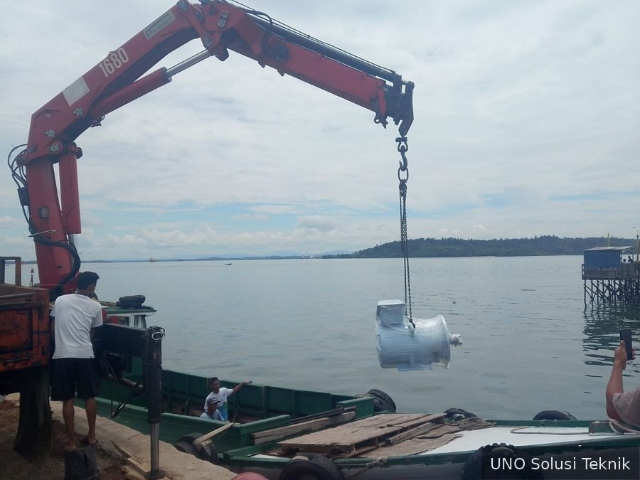 Crane mengangkat motor untuk dipindahkan ke kendaraan